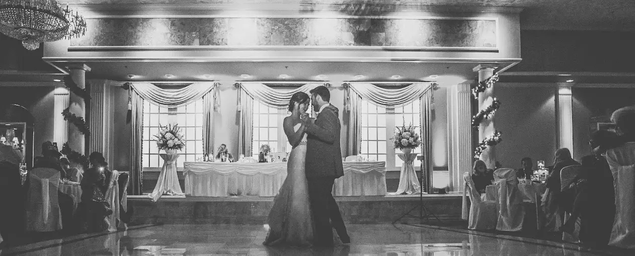 Grand ballroom at Cotillion Banquets set for a wedding reception: crystal chandeliers, porcelain dance floor, and elegantly set tables